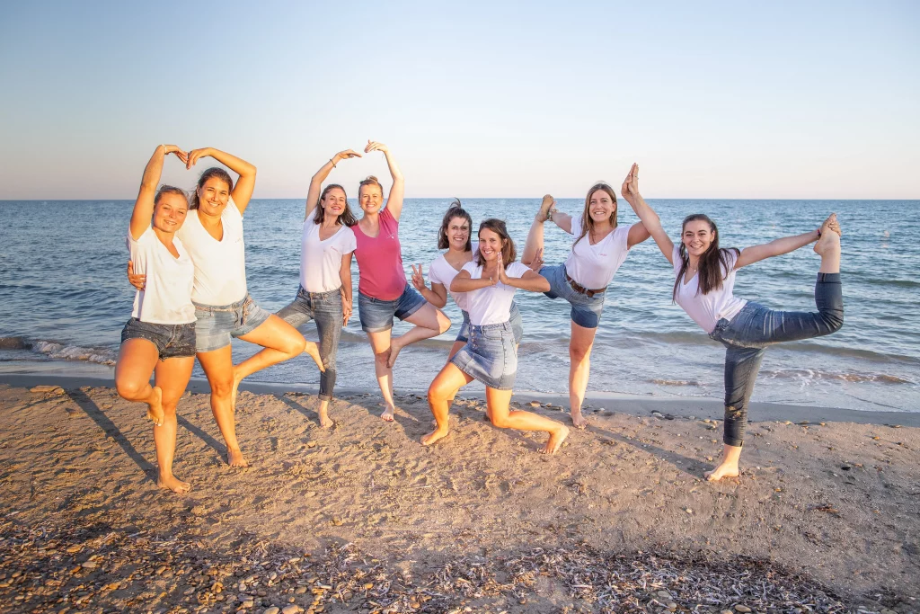 séance photo evjf, les filles sont sur la plage et font une photo de groupe en faisant des pauses de yoga