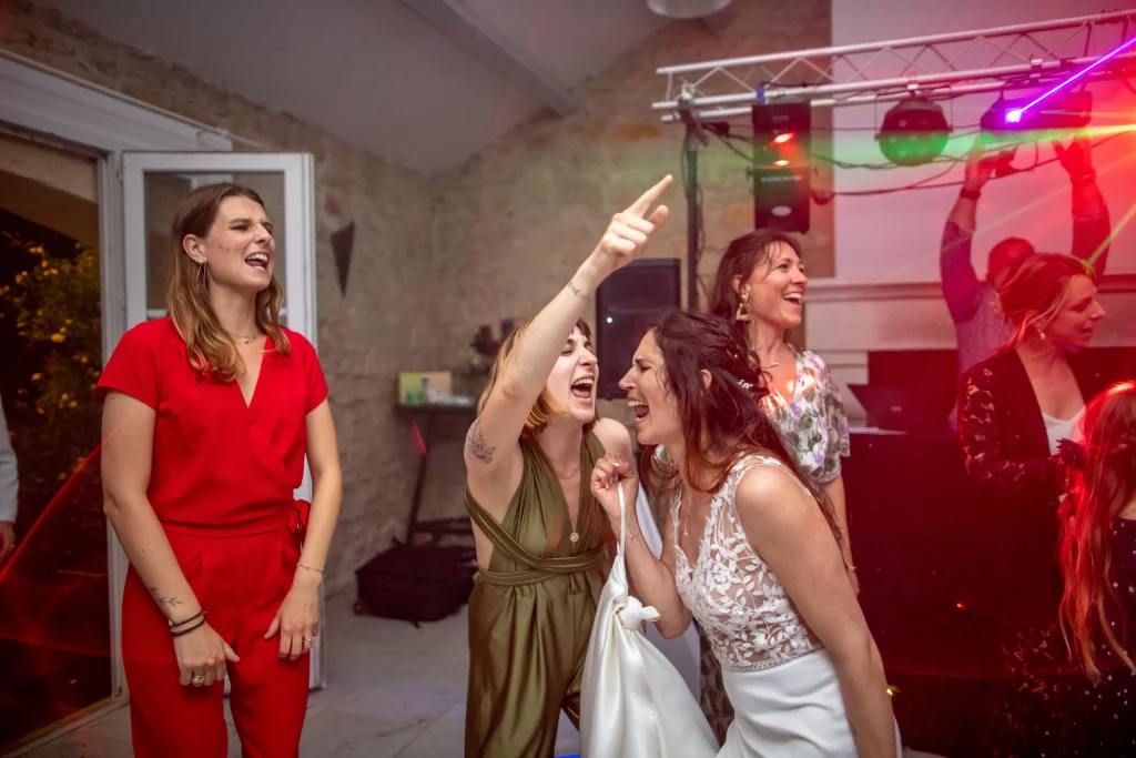 photo de soirée lors d'un mariage, la mariée chante sur la piste de danse avec ses copines