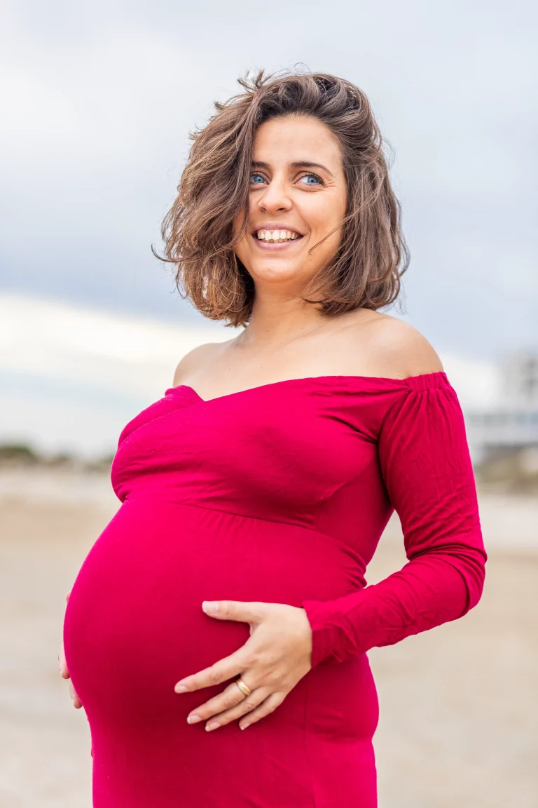 photo de grossesse sur la plage dans une robe rouge