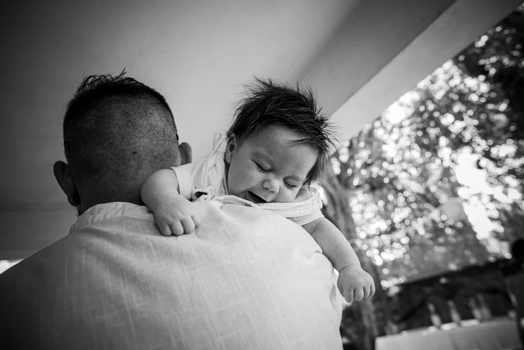 photographie de baptême papa qui fait un câlin à son enfant