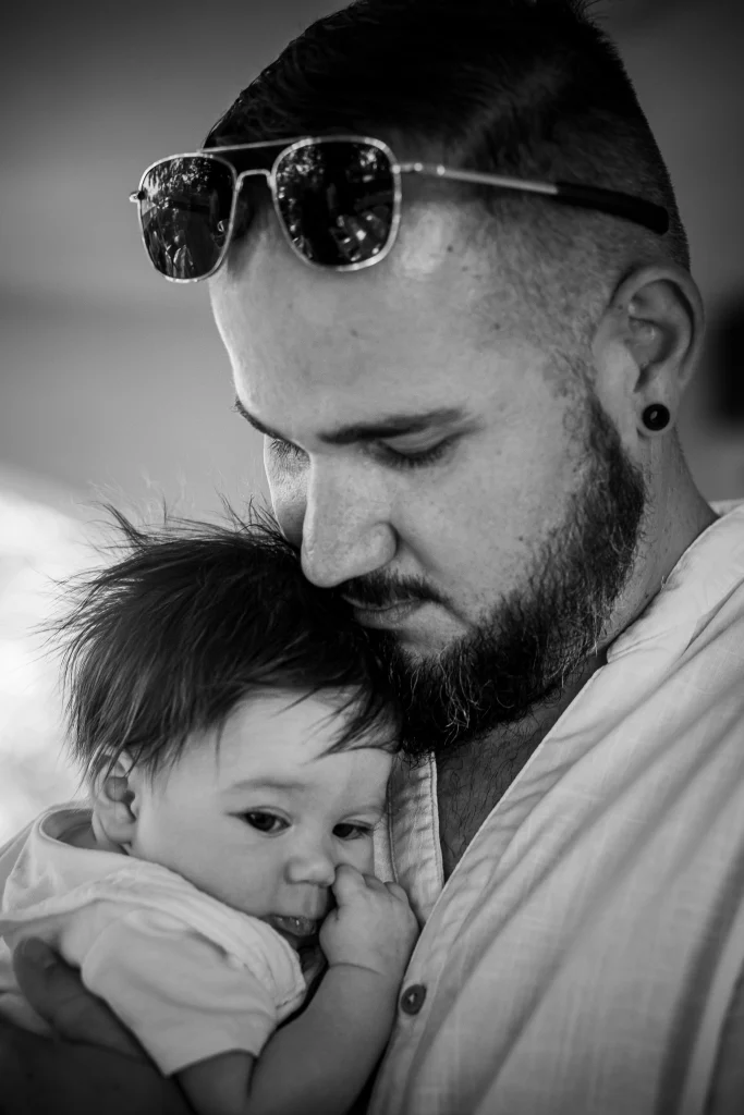 photographie de baptême papa qui fait un câlin à son enfant