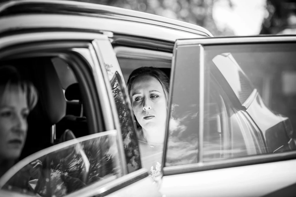 arrivée de la mariée qui stress dans la voiture devant la mairie photo en noir et blanc faites par un photographe professionnel