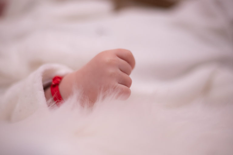 photographie de nouveau-né, de sa petite main, faites par un photographe professionnel de naissance et bébé