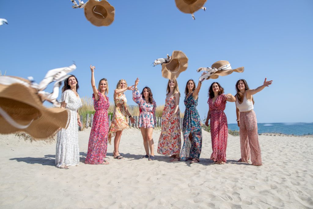 groupes de filles, sur une plage qui jettent leurs chapeaux pendant un EVJF
