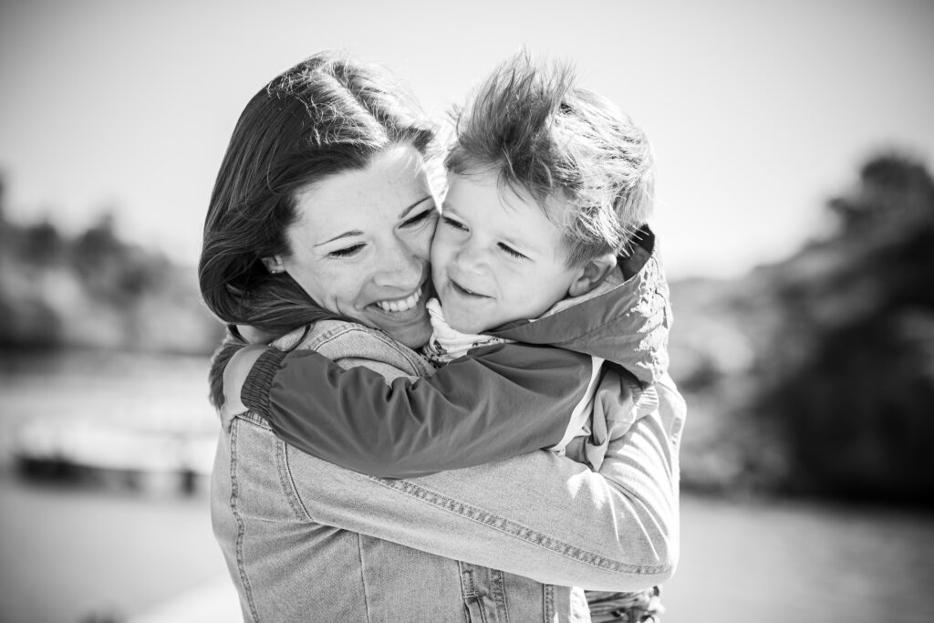 séance photo de famille faites par un photographe de famille à montpelllier, les deux parents ont les enfants sur les épaules et marche tranquillement en rigolant