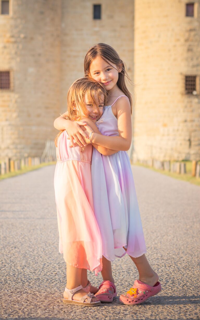 Photo de famille, lors d'une séance photo famille faites par un photographe professionnel; deux petites filles se font un câlin