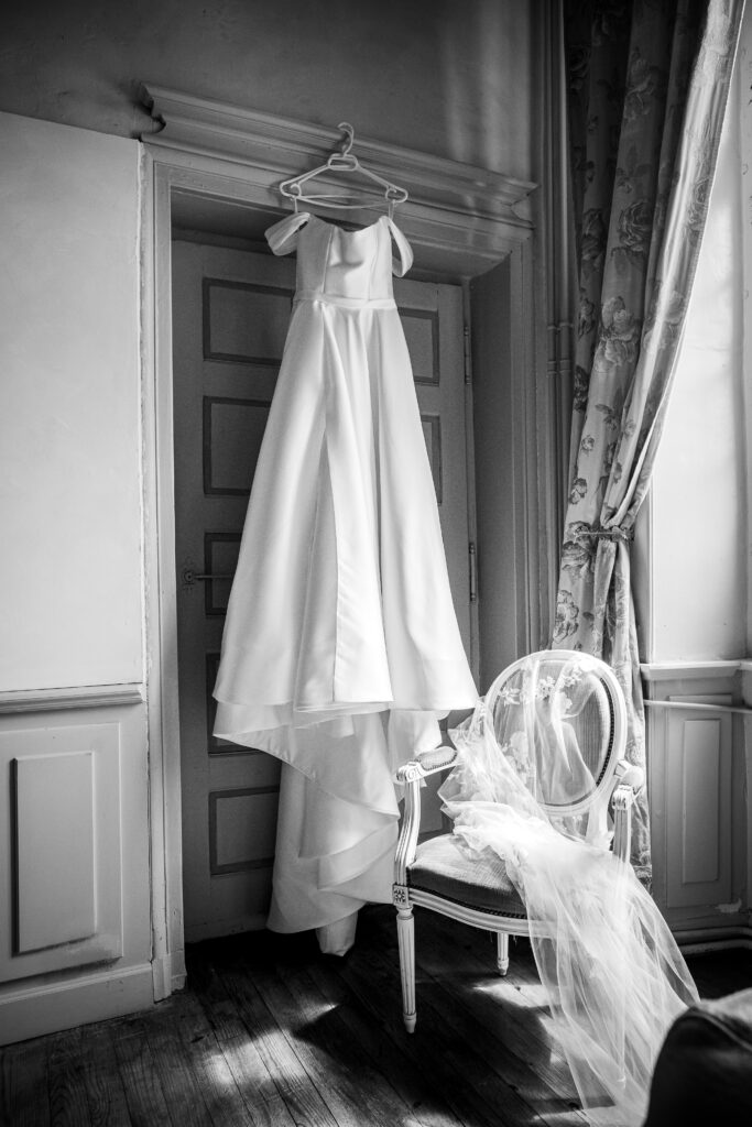 Mariage de Eleonore et Louis dans l'Hérault, photo faite dans un chateau. Photographie en noir et blanc de la robe de mariée et du voile de la mariée