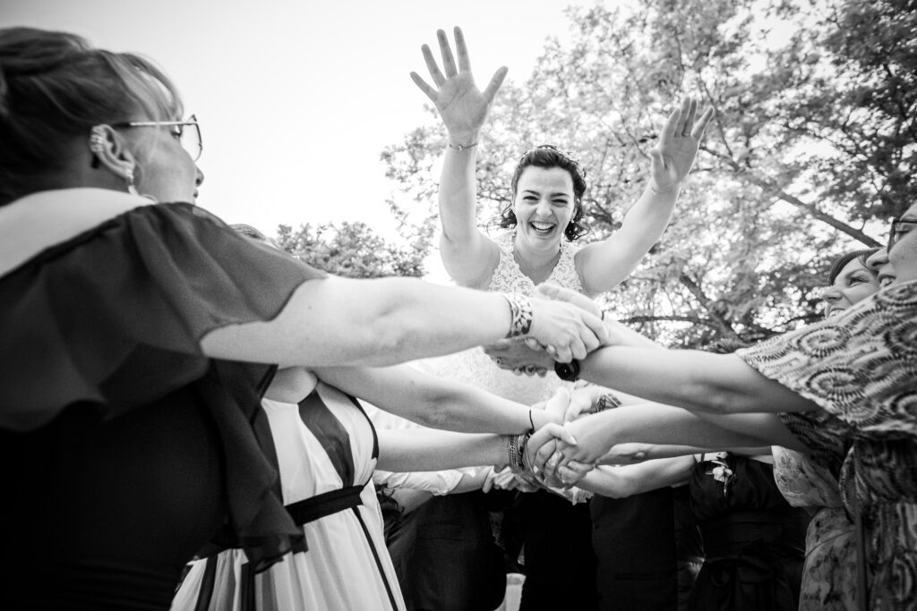 mariage de Elisa et Alexis, la mariée est envoyé en l'air par ses invités durant les photos de groupe à Alès