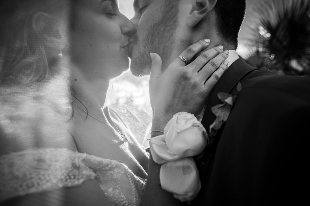 Mariage de Juliette et William, les deux mariées s'embrasse sous le voile, en noir et blanc. photographie de mariage faite par romain graille photographe de mariage