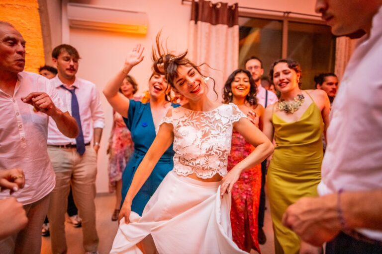 photographie de mariage de Mélanie et Alban, la mariée danse sur la piste avec ses cheveux aux vents, photographie faite par un spécialiste de la photographie de mariage dans le Gard, le meilleur photographe du GARD