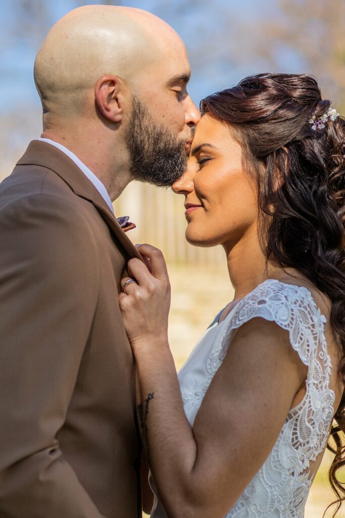 Mariage de Naomie et Romain à Alès, le marié embrasse la mariée sur le front