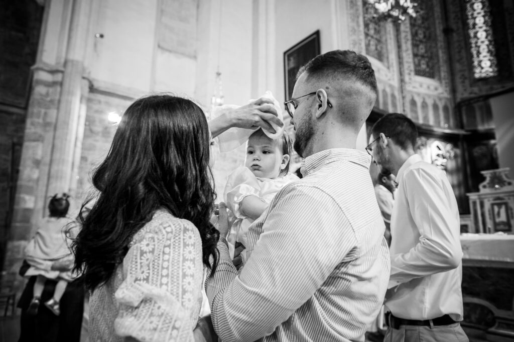 photographie de baptême religieux, les parents essuie la tête de l'enfant après sa communion avec dieu