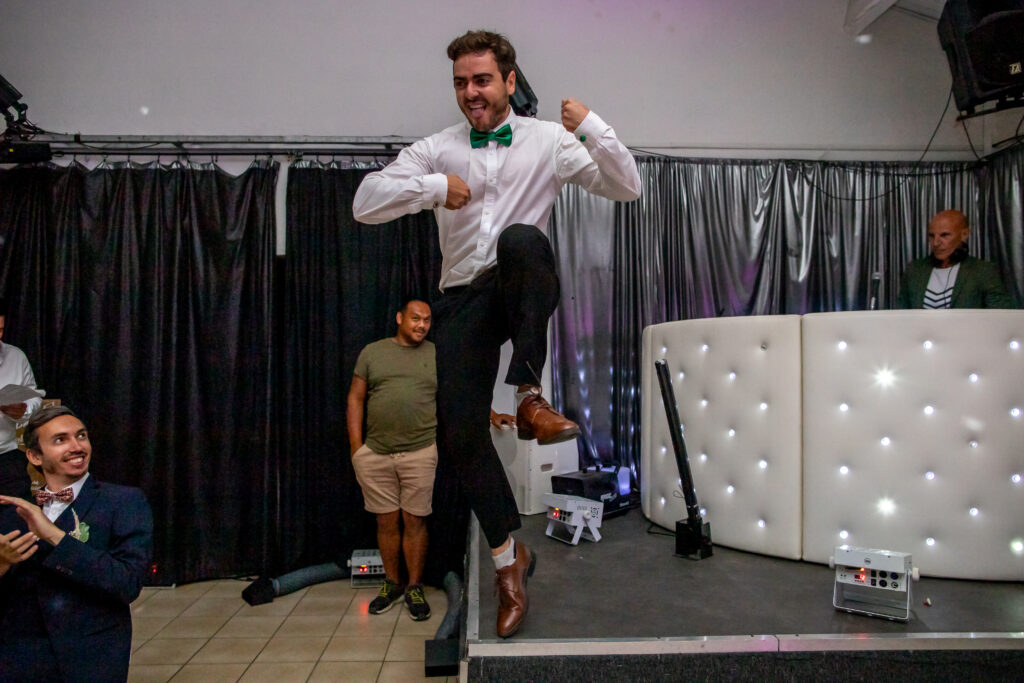 photographie d'un invité de mariage à Nîmes qui saute en l'air en faisant du air guitare