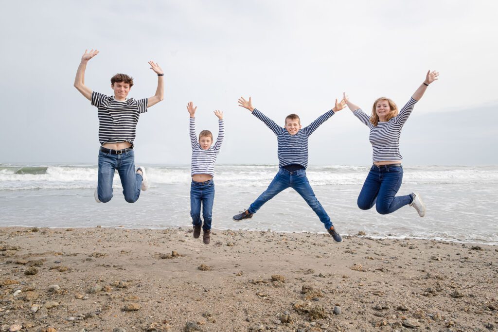 photographie de 4 enfants qui sautent en même temps durant une séance photo famille à Montpellier sur le bord de plage