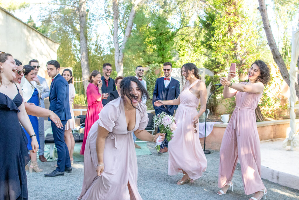 photographie du mariage de Soraya et Cédric à Alès, la témoin attrape le bouquet de la mariée et elle crie