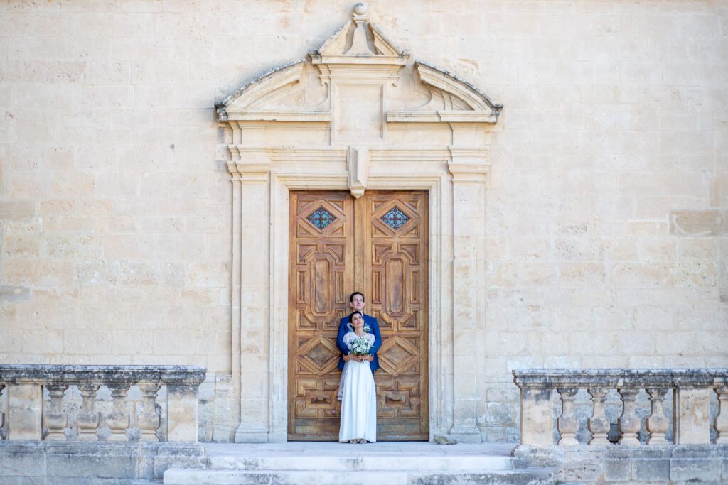 Mariage de Elise et Joshua à Alès, photographie devant une porte en bois d'un château