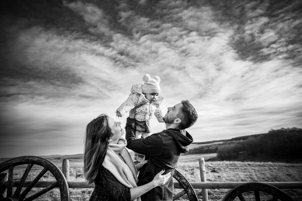 Durant une séance famille deux parents lèvent leurs bébé au ciel dans une magnifique photo en noir et blanc prise à Montpellier par Romain Graille photographie.