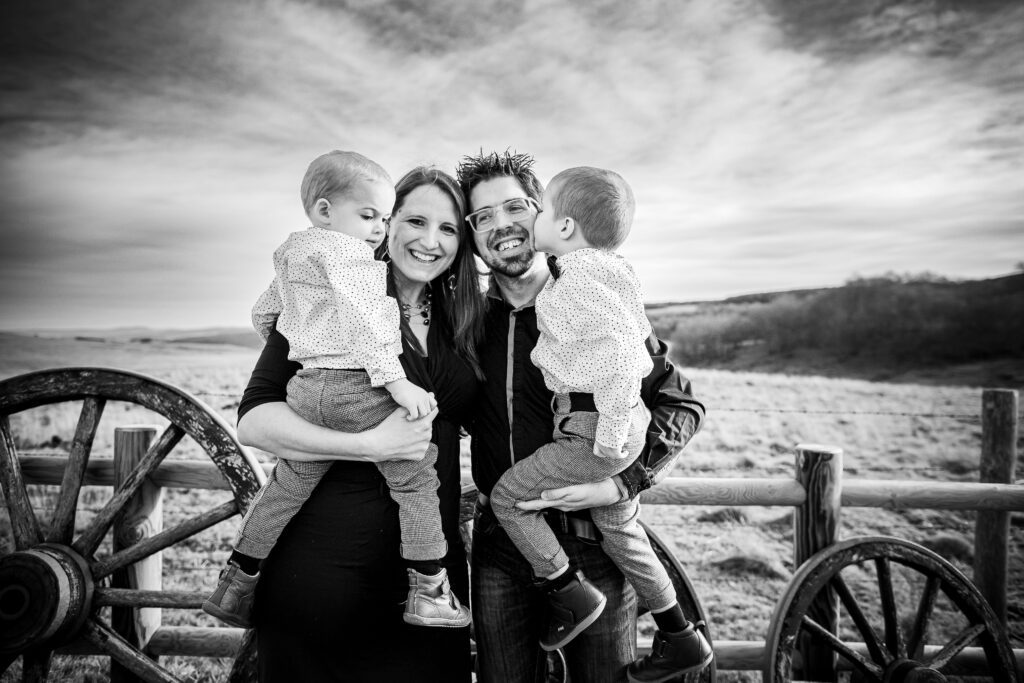 photographe famille à Béziers, romain vous propose des images pleine de douceur et de sincérité, comme cette photo en noir et blanc d'un couple et de leurs deux garçon qui se font un câlin dans une magnifique photo en noir et blanc